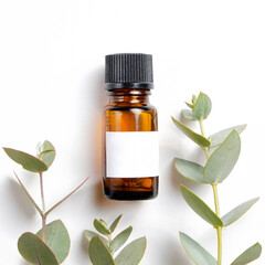 Brown transparent glass bottle with black cap and blank label with copy space for text or logo, white wood textured table background. Essential oils for aroma therapy. Close up, copy space, top view.