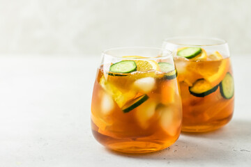Refreshing fruit cucumber orange iced tea in glasses. Space for text.