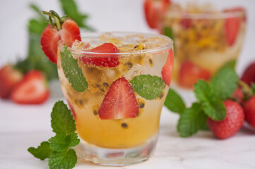 the passion fruit cocktail with mint and ice cubes in glass, homemade fresh fruit, passion and strawberry  sweet fruit drinks, fruit drink for healthy concept, selective focus.