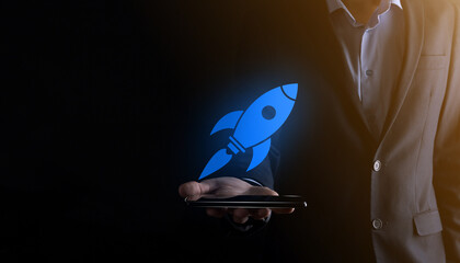 Start up concept with businessman holding abstract digital rocket icon rocket is launching and soar...