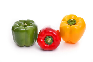 Three bell peppers, red, green and yellow on white background,