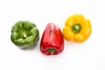Three bell peppers, red, green and yellow on white background,