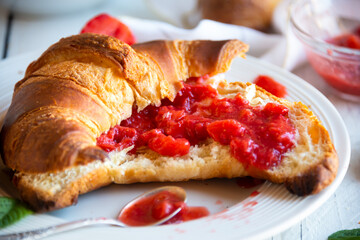 Croissants with strawberry jam and fresh fruit, delicious and healthy breakfast