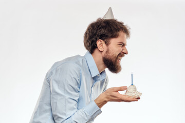 a man with a beard holds a cake in his hand on a light background birthday