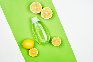Lemon-based skincare gel on bright colorful background. Top view of lemon slices and cosmetic gel bottle