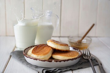 Japanese pancakes on a white plate on a white table. Puffy pancakes with honey