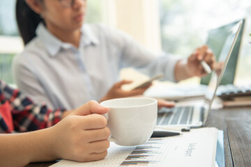 Business meeting time. Photo young account managers crew working with new startup project. Notebook on wood table. Idea presentation, analyze plans. Wide,film effect