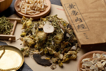 Ancient Chinese medicine books and herbs on the table.English translation：Emperor's Internal...
