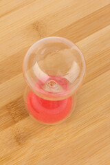 Crystal hourglass on wooden background as a concept of passing time for business term, urgency and outcome of time.