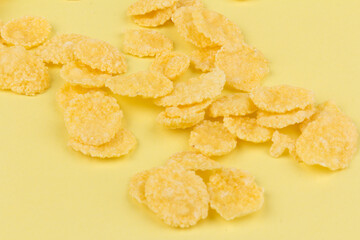 Pile of yellow cornflakes on yellow  background