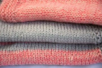 Colored jersey items are stacked. Pink jersey with gray stripes. Knitted fabric.