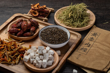 Ancient Chinese medicine books and herbs on the table.English translation：Emperor's Internal Classic