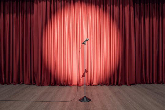 Speaker performance concept with round spotlight on red curtain and microphone on wooden floor of empty stage