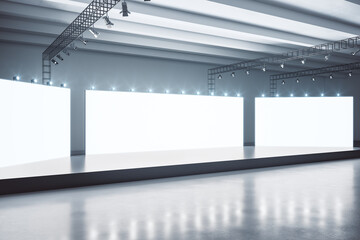 Modern spacious exhibition hall with blank white boards, gloosy black stage and dark floor. Mock up