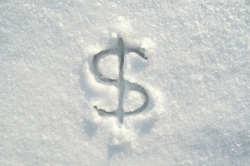 Dollar sign written in pure snow on a sunny winter day. View from above. 