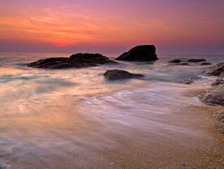 Beautiful natural seascape wave moving on the rock during sunrise