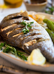 Roasted dorado fish with herbs and vegetables , healthy food