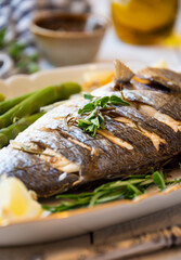 Roasted dorado fish with herbs and vegetables , healthy food