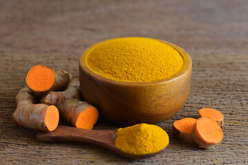 Turmeric powder and fresh turmeric (curcumin) on wooden background,For cooking and for herbs.