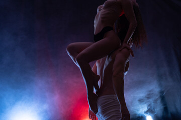 Silhouette of sexy woman in underwear seducing a guy with blue and red background. Concept of attraction, domination and sexuality 