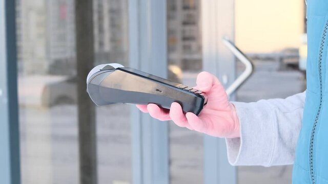 Pos terminal in the hand of a man. Banking equipment. Acquisition. Acceptance of bank credit cards. Contactless payment.