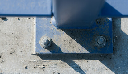 Strong screw used for railing next to a road. Close up industrial view.