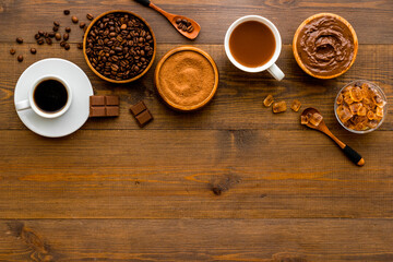 Coffee beans and powder with hot chocolate in white cup. Top view, flat lay