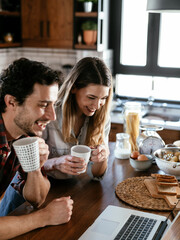  Loving couple drinking coffe in the kitchen. Happy smiling woman enjoy in the morning with her boyfriend.