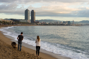 Una pareja pasea el perro por las playas de Barcelona