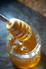 Fototapeta na wymiar honey dripping from a wooden spoon