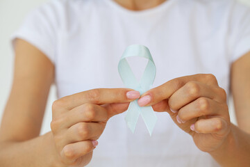 Woman with blue ribbon, prostate cancer awareness