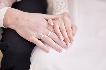 Wedding rings on a pair of bride and groom. Close up, copy space