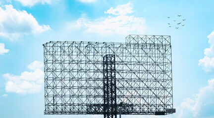 Empty advertising billboard structure against blue sky