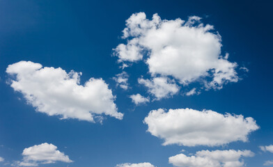 Azure sky background with white fluffy clouds in the fresh sunny day.