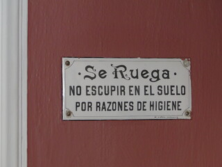 Curioso letrero antiguo a la entrada de un edificio público en España en el que está escrito que se ruega no escupir en el suelo por razones de higiene