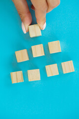 Woman hand putting and stacking blank wooden cubes on desk with copy space for input wording and infographic icon.