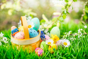 Beautiful easter basket with easter eggs. Easter basket with sweets and colorful eggs in...