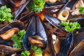 Boiled mussels in cooking dish with parsley on a wooden background © Andreas Fischer