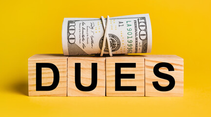 dues with money on a yellow background. The concept of business, finance, credit, income, savings, investments, exchange, tax