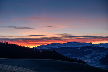 colorful sunrise over Hohgant with trees