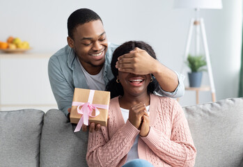 Cheerful black man making surprise for his wife