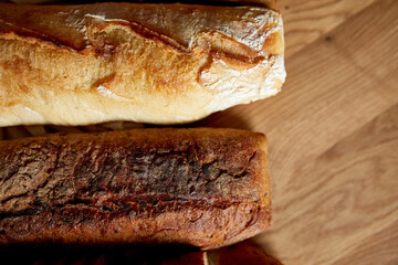 Top view of various kinds of bread on a wooden surface.