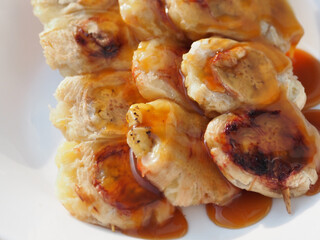 Grilled banana with fragrant caramel sauce from Thailand on white background.