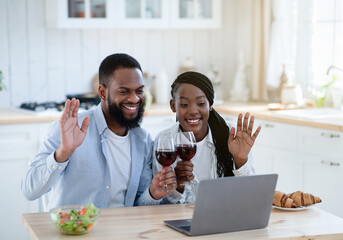 Online Party. Cheerful Black Couple Making Video Call With Laptop In Kitchen
