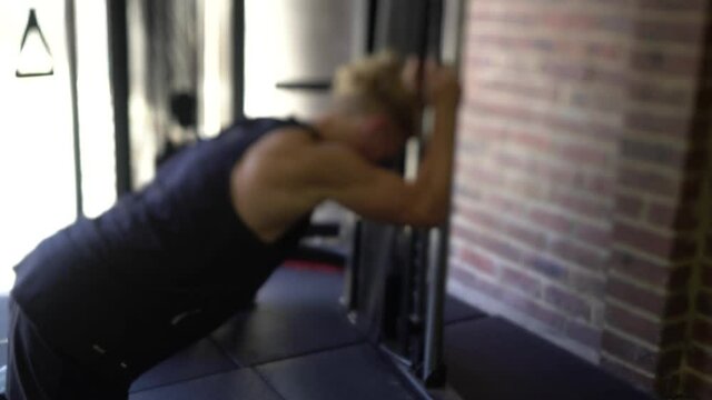 Tattoo man muscles in home gym cable ab crunch