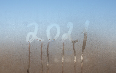 2021 lettering on misted glass. The concept of the outgoing year.