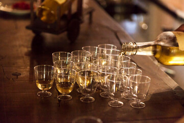 Glasses of (cachaça) in a (cahcaçaria) tasting with a rustic climate, woody counter and drinks being prepared. Cachaça concept. Drink concept.
