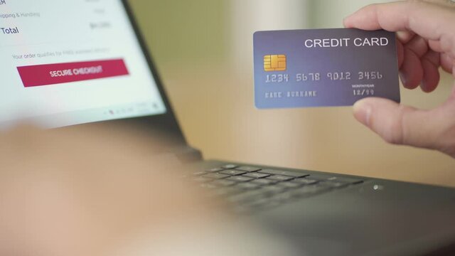 Indoor shot of men hand while typing on computer for credit card mock up number information and CCV security code before purchase for online shopping payment transaction. Digital banking with internet