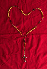 Fototapeta na wymiar Rosary beads on red background.