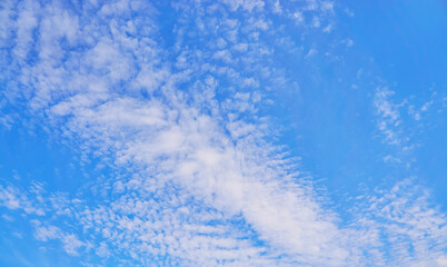 Blue background with elongated white clouds.